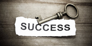 key lying on paper saying word success